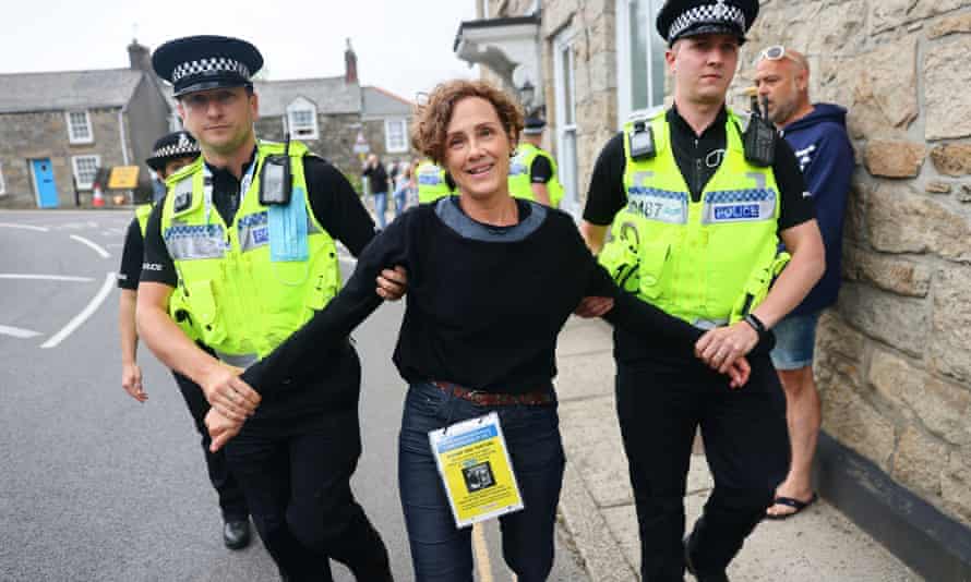A protester is led away by police, in Lelant, next to Carbis Bay