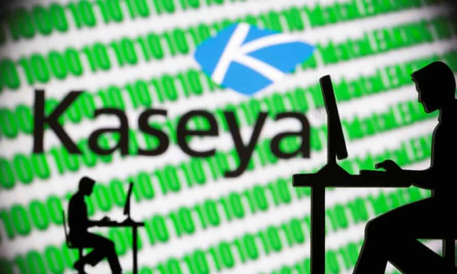 Men working on computers in front of a Kaseya logo